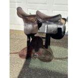 Two children's leather saddles with a training saddle pad