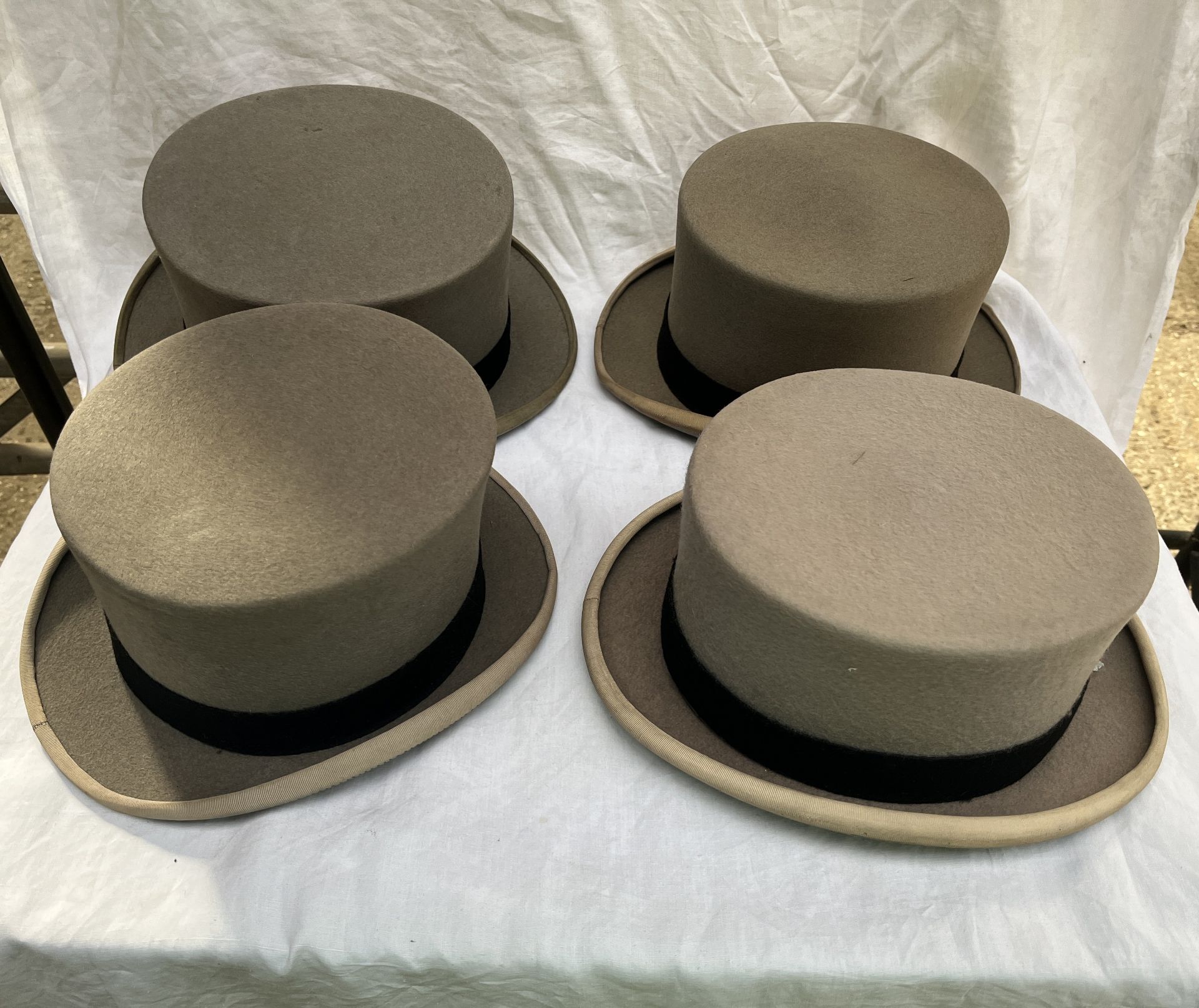 Four grey top hats; three 7 1/4 and one small