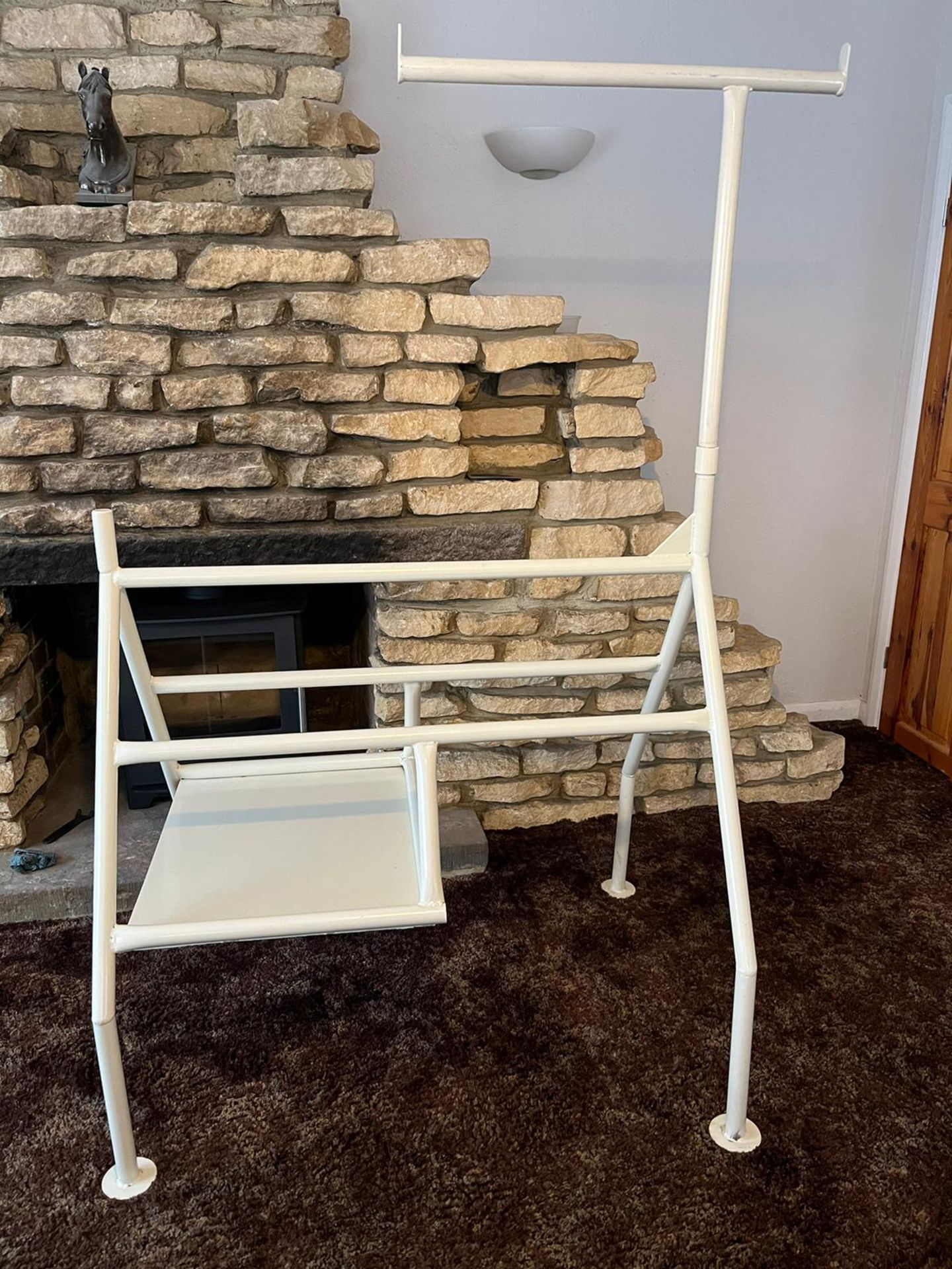 Harness horse, powder coated in cream/off white. Steel tubular construction.