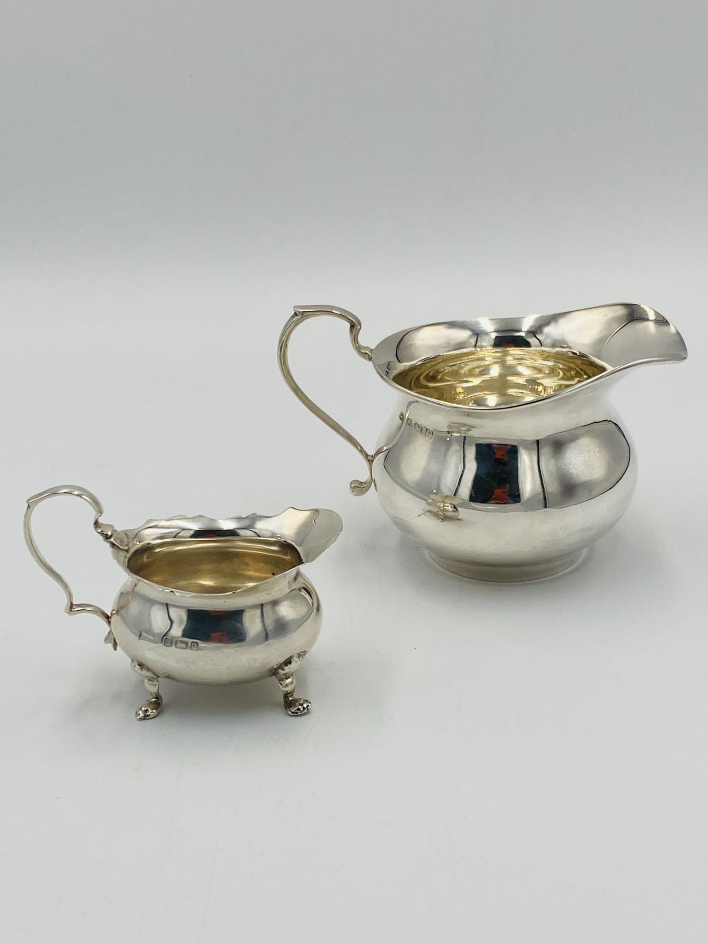 Two silver milk jugs