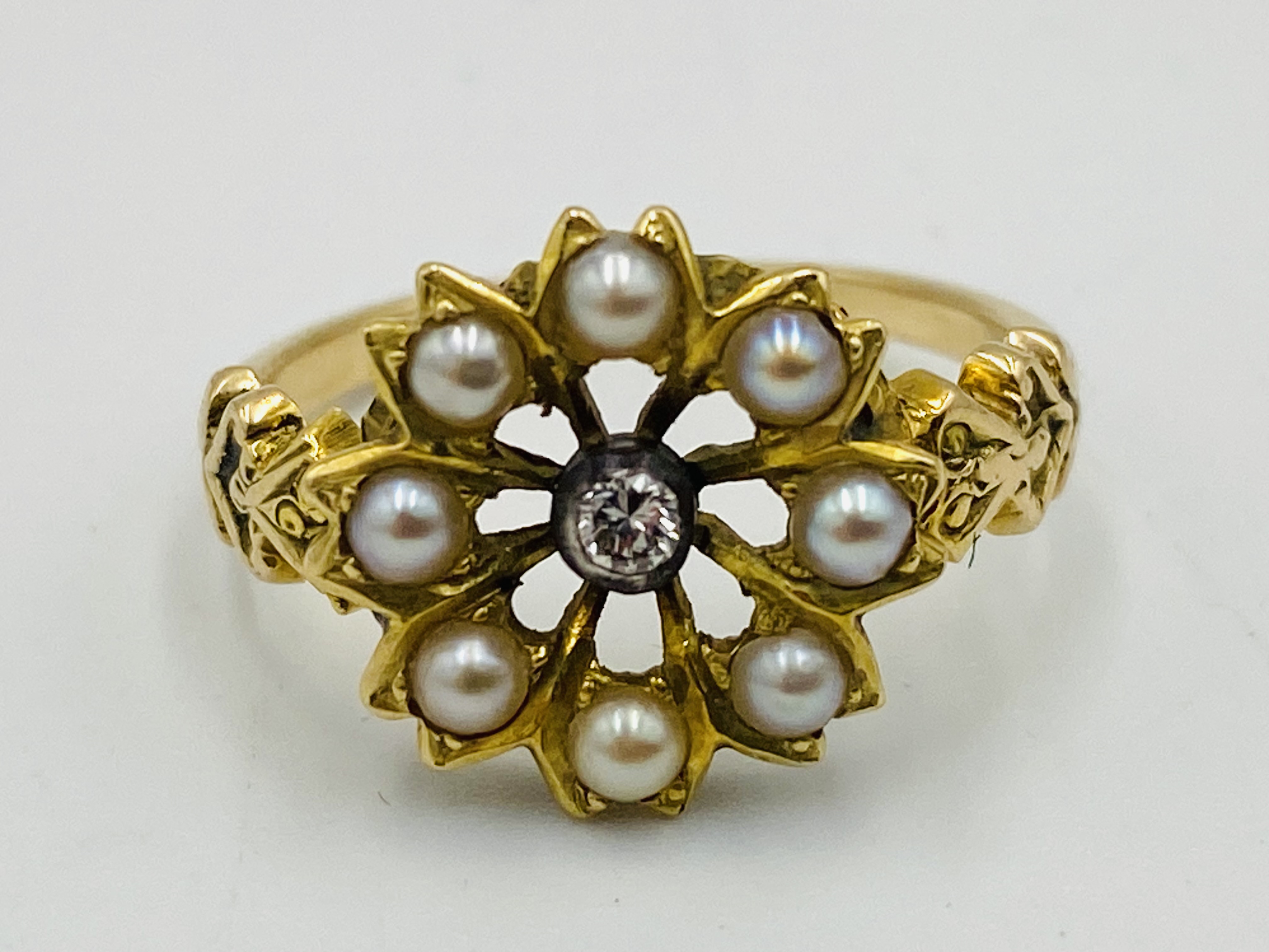 18ct gold ring set with central diamond and seed pearl surround