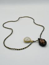 Bead necklace with pendant depicting a reclining Buddha and a 'Bia Kae' pendant.