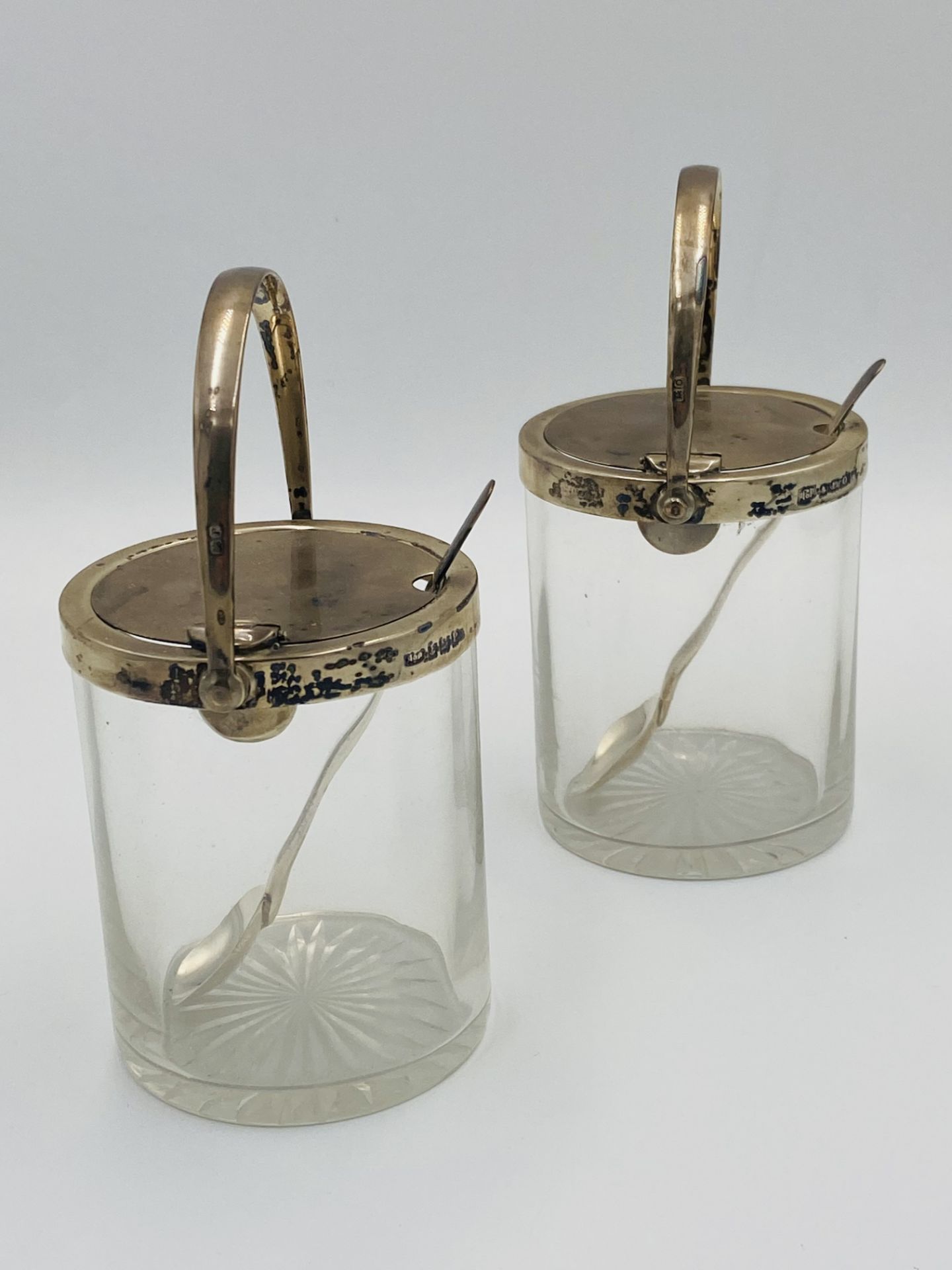 Pair of silver mounted, glass preserve jars with star cut bases