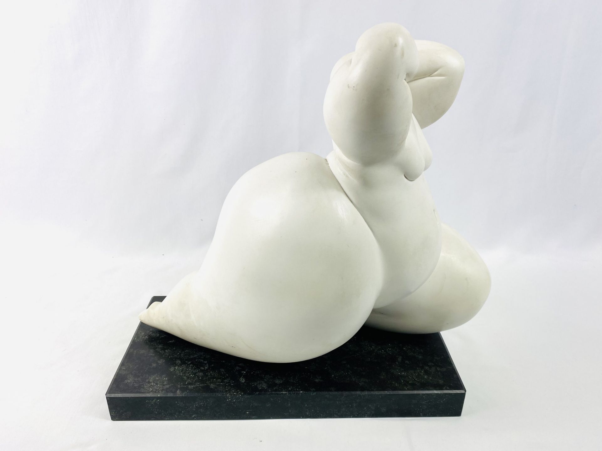 Composite sculpture of a female figure on a stone base