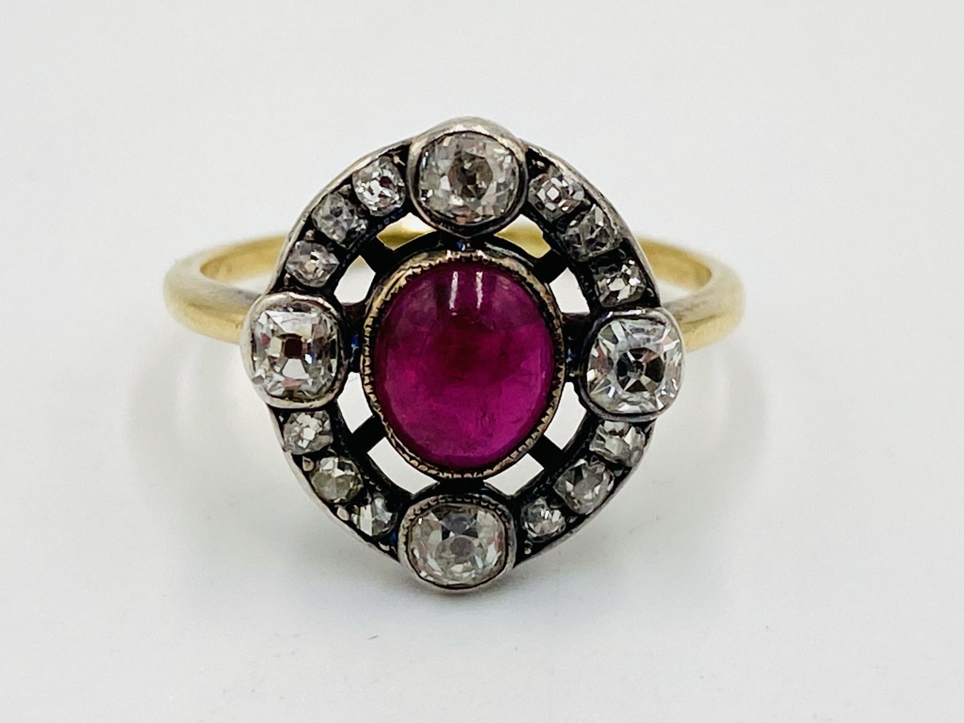 Gold ring set with a centre ruby and diamond surround
