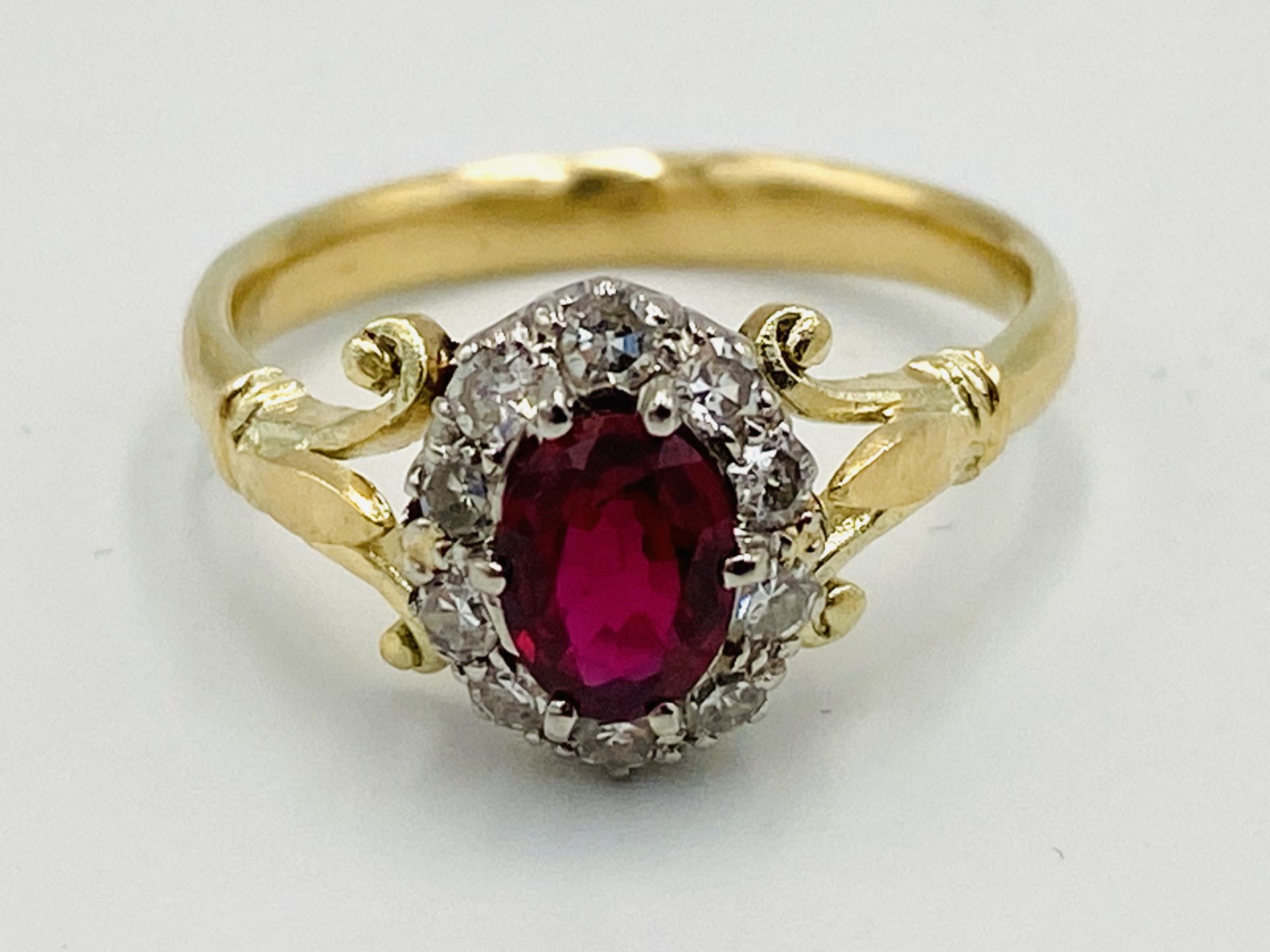 Gold ring set with central ruby and diamond surround