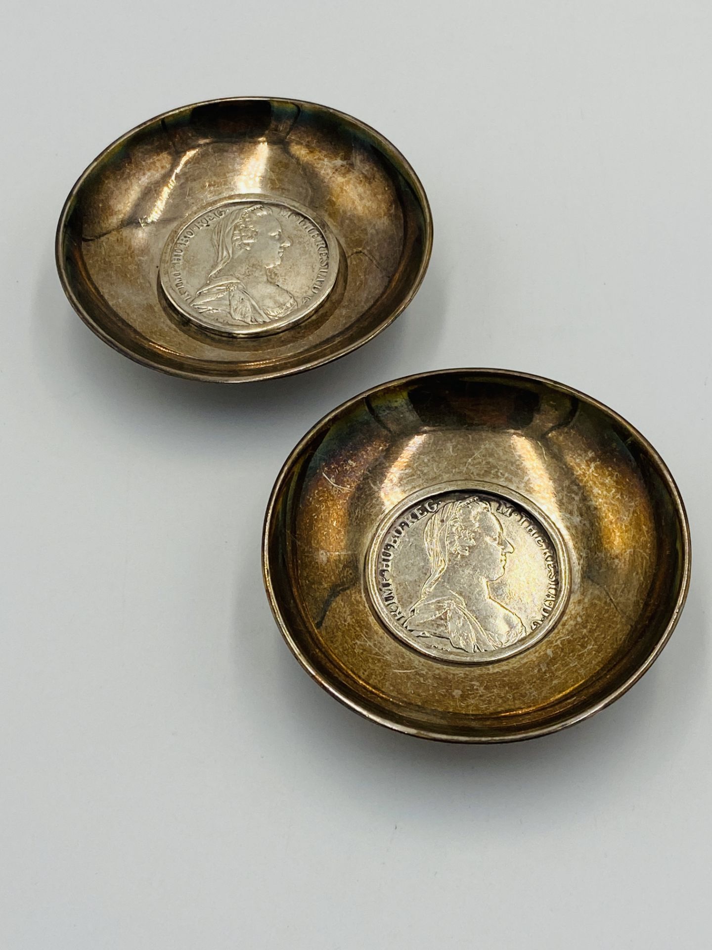 Two silver plate dishes set with a 1780 Maria Theresa silver thaler to centre.