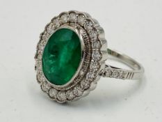18ct white gold ring set with a oval emerald and diamond surround