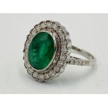 18ct white gold ring set with a oval emerald and diamond surround