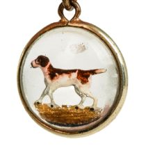 A late 19th/early 20th century reverse painted crystal circular pendant, depicting a hound, approx