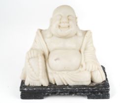 A carved alabaster figure of the laughing Buddha, hotei, 15 cm tall. Minor nibbles to the base.