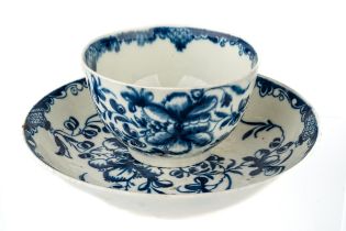 An 18th century Worcester blue and white tea bowl and saucer, the saucer having a crescent back
