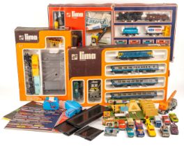 A collection of boxed Lima model trains and associated model railway furniture and die cast cars.