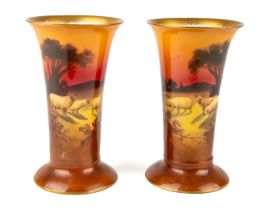 A pair of Royal Doulton tapered cylindrical vases, depicting sheep in a landscape at sunset,