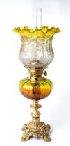 A Victorian oil lamp with gilt metal base, brass fittings, amber and green body and green etched