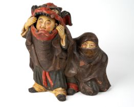 A Chinese terracotta figure of boys playing in Chinese dragon costume, character marks to back, hand