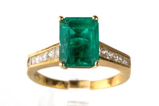 An 18k yellow gold emerald and diamond ring, the step-cut emerald approx 9.5mm x 7mm, in four