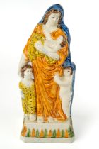 A late 18th century Staffordshire pearlware figure of Charity, c.1780-1800, standing holding a