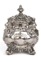 A Victorian silver-plated tea caddy, of shaped square form cast with foliate scrolls, the cover with