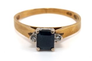 A gold sapphire and diamond ring, the central square-cut sapphire flanked by two round brilliant -