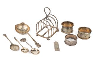 A collection of silver, including a five-bar toast rack; three napkin rings; a straining spoon;
