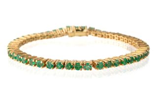 A yellow metal and emerald line bracelet, set with round-cut emeralds in prong settings, box clasp