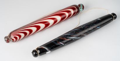 A 'Bristol' glass rolling pin, the clear body with red glass striations full of salt, 36cm long;