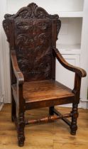 A Victorian oak Wainscot chair, carved arched back, scrolled arms, boarded seat, turned legs and