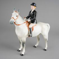 A Beswick model of a Huntswoman on a dapple horse, she wears black jacket and bowler, stamped