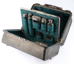 A late Victorian gentleman's leather travelling vanity case enclosing five silver topped dressing