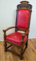 A Gothic style carved oak throne chair, red leather seat and backing, with carved lettering on the