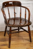 A late 19th Century oak captain's chair, with pierced splat, spindle back, shaped seat and turned