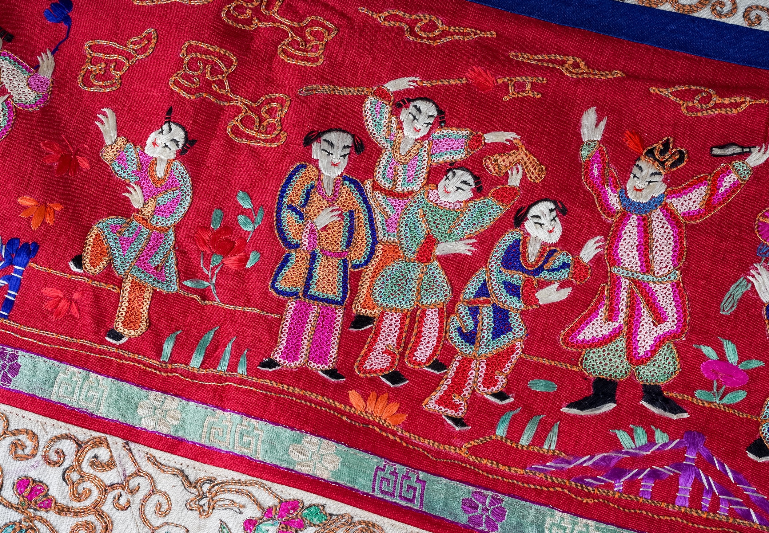 A Chinese embroidered silk wall hanging, the central section with central seated Deity and child