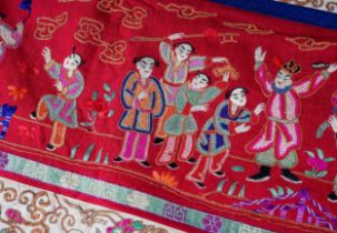 A Chinese embroidered silk wall hanging, the central section with central seated Deity and child