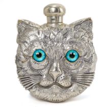 A continental white metal novelty scent bottle, cast both sides as a cat's face with blue glass