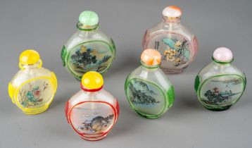 A collection of Chinese clear glass snuff bottles, each reverse painted depicting traditional