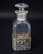 An Art Nouveau silver and glass scent bottle, the silver sleeve embossed with leaves and berries