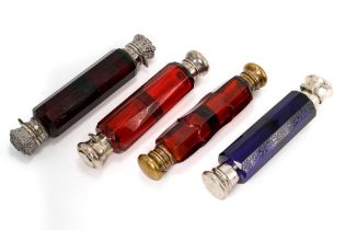 A collection of four Victorian double-ended glass scent bottles, including three red and one blue,