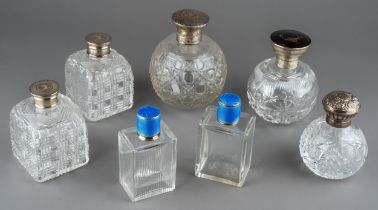 A collection of seven silver mounted cut glass scent bottles, including a matched pair of Art Deco