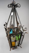 A Victorian cast metal tapering hall lantern with raised supports, leaf motifs, twist side supports,