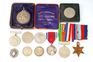 A World War II trio of medals, unnamed; a George V and Queen Mary 1910-1935 Jubilee medal; a