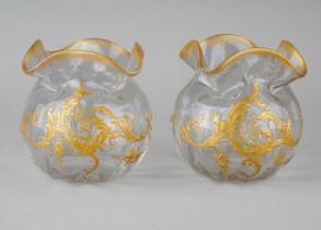 A pair of early 20th Century glass vases, pinched rim, the bodies overlaid with gilt decoration,