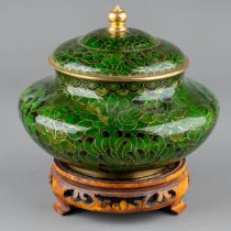 A Chinese green Cloisonné pot and cover, with lotus flower decoration, on carved stand, the pot