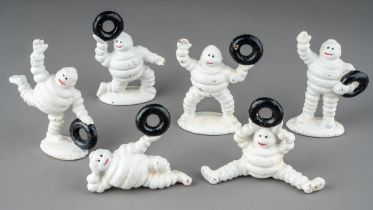 Six vintage cast metal Michelin men all holding tyres, in various poses, the tallest approx 8.5cm