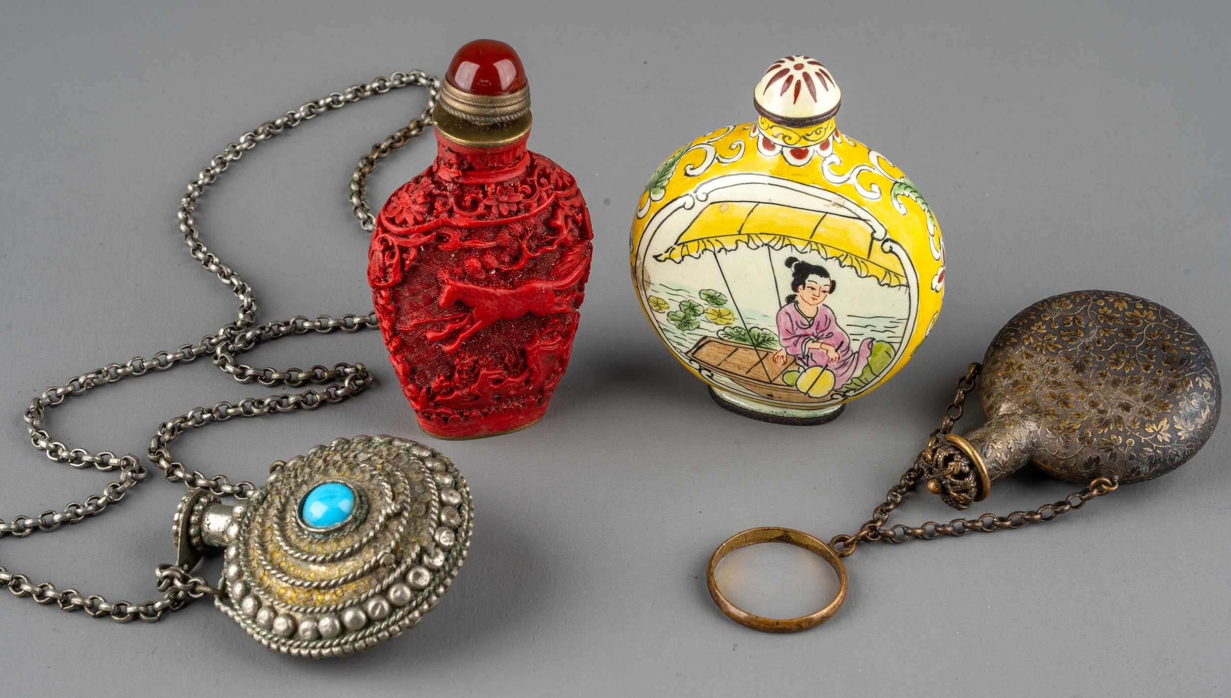 A collection of Chinese snuff bottles, including an ovoid cinnabar bottle depicting horses amongst