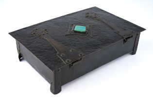 An Arts and Crafts rectangular copper box, the hammered cover with strapwork hinges, central