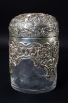 A Victorian silver mounted cylindrical scent bottle, the hinged domed cover embossed with foliate