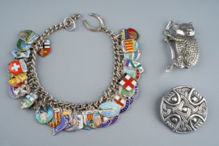 A silver charm bracelet, with enamelled souvenir charms; a Scottish silver brooch, makers mark RA,