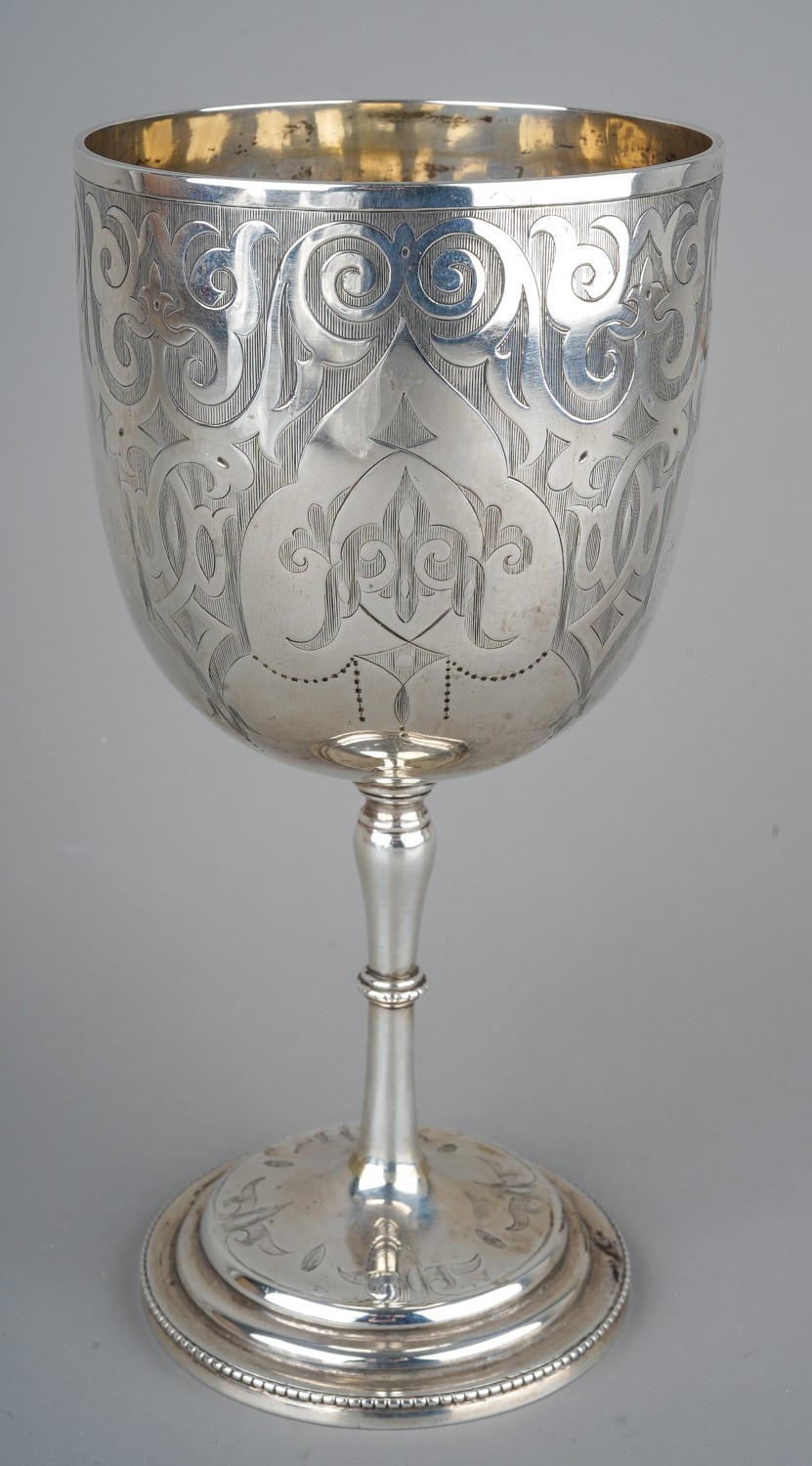 A Victorian silver goblet, engraved scrolling detail, vacant cartouche, on a stepped circular