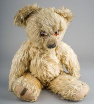 A 1930's Merrythought teddy bear, with blonde mohair, one orange and black glass eyes, black
